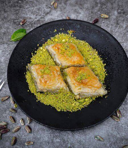 dark plate with three pieces of baklava