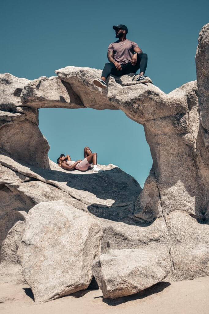 man and woman sitting on rock formation