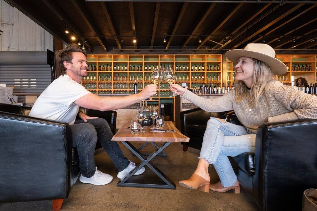 a man and a woman clinking wine glasses