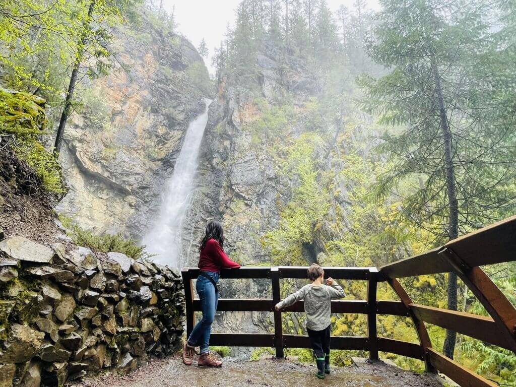 a woman and boy stand at overlook of Copper Falls surrounded by thick forest