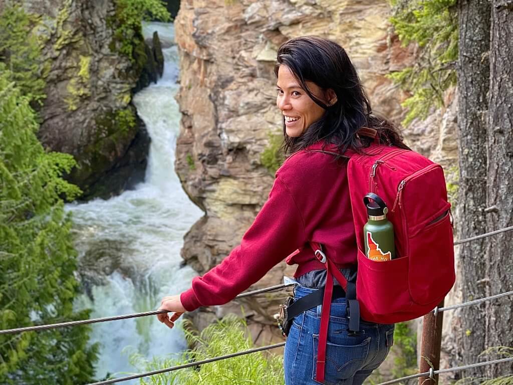 Water tumbles down Myrtle Falls near Bonners Ferry while woman looks at water from overlook area