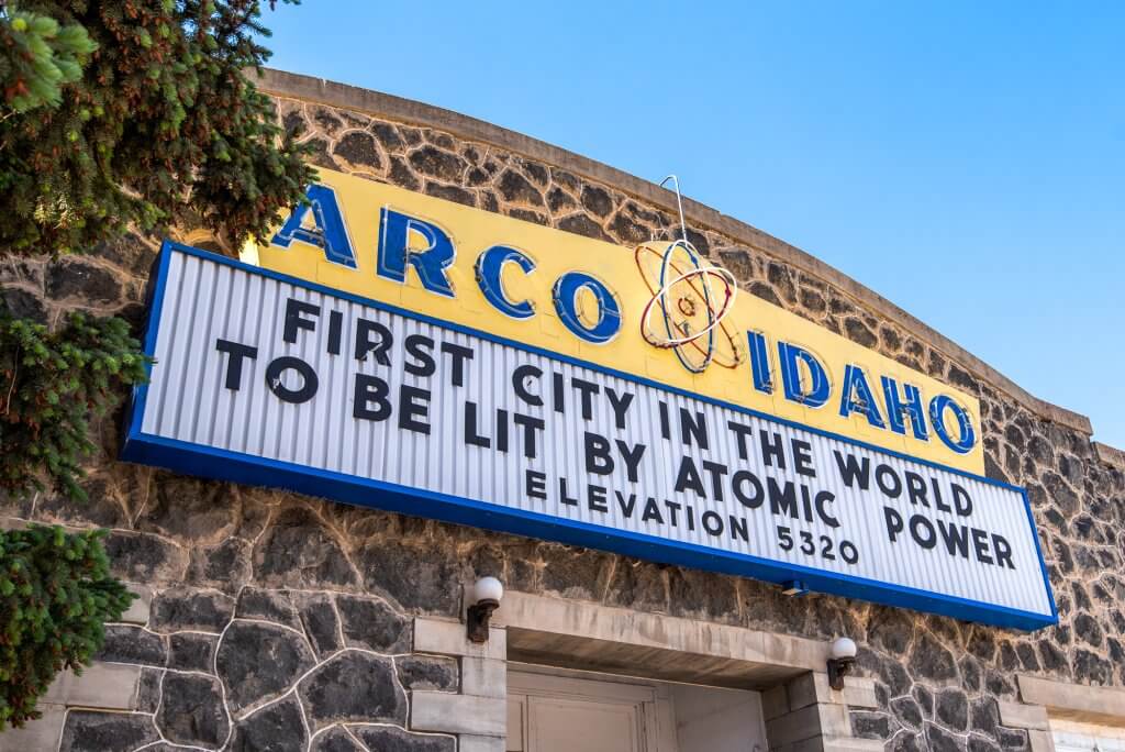 sign on front of old rock building acknowledging Acro as the first city lit by atomic power