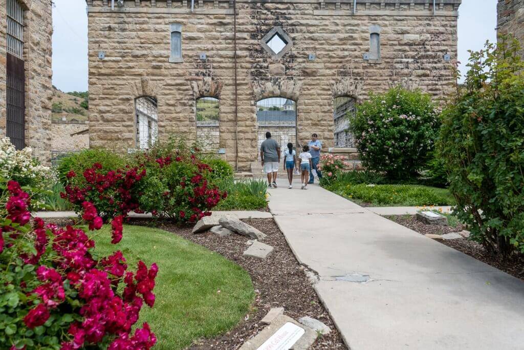 dad and two daughters with a tour guide standing in front of Old Idaho Penitentiary 