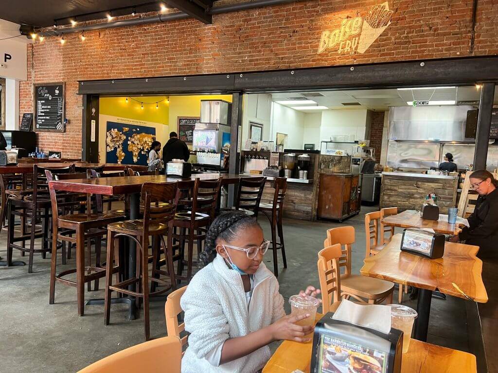 young girl sitting at table inside Boise Fry Company