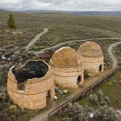 Aerial view of three stone charcoal kilns surrounded by an open landscape of brush, at the Charcoal Kilns Interpretive Site.