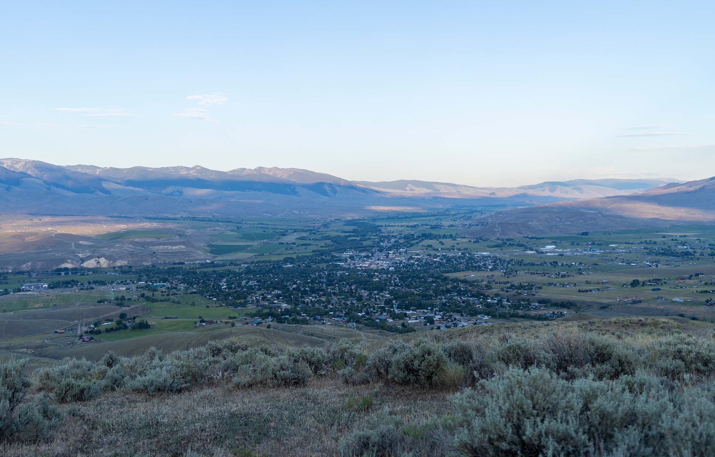 View overlooking the town of Salmon with the city shown surrounded by mountains and greenery.