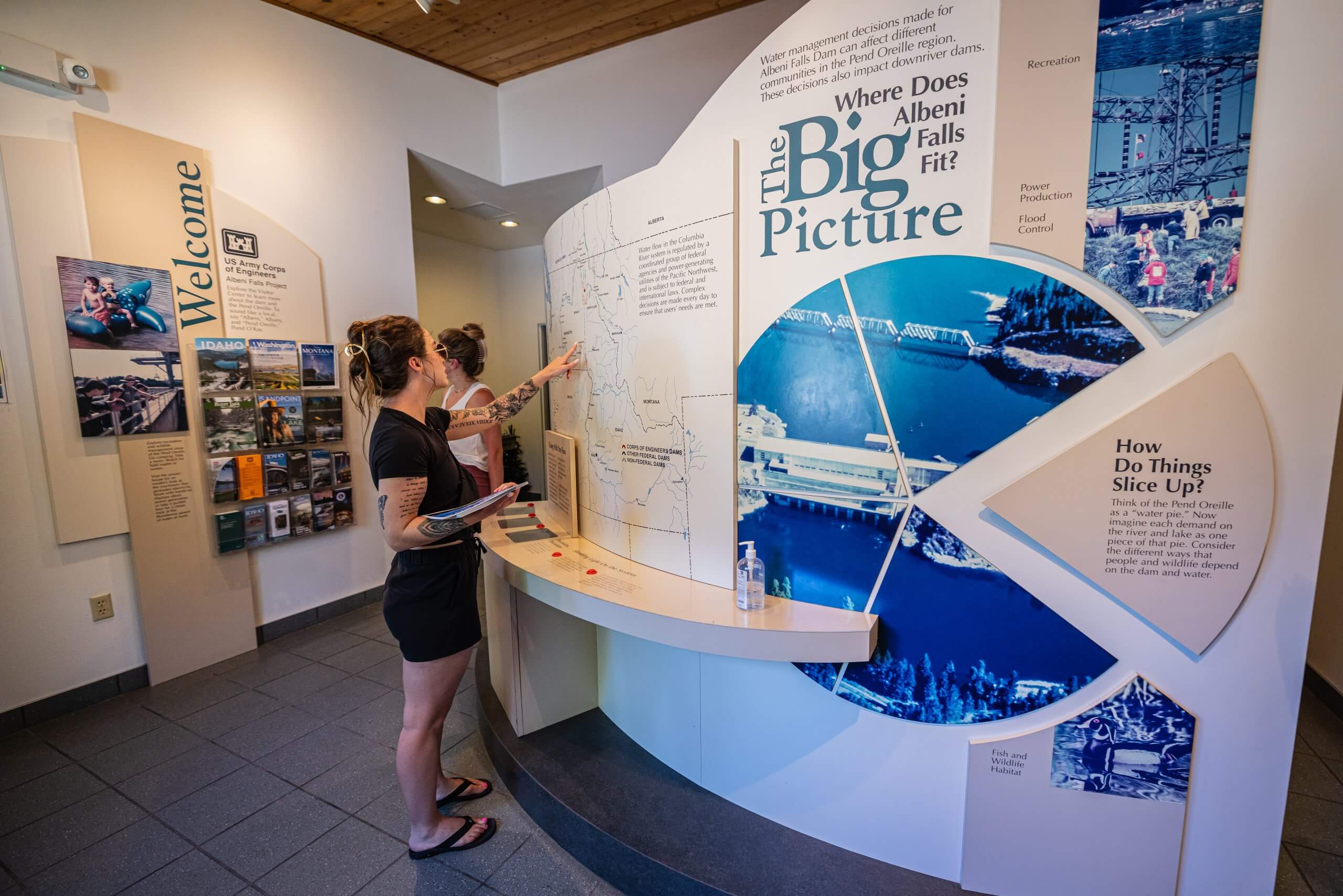 a woman points to a map at the Albeni Falls Dam Visitors Center.