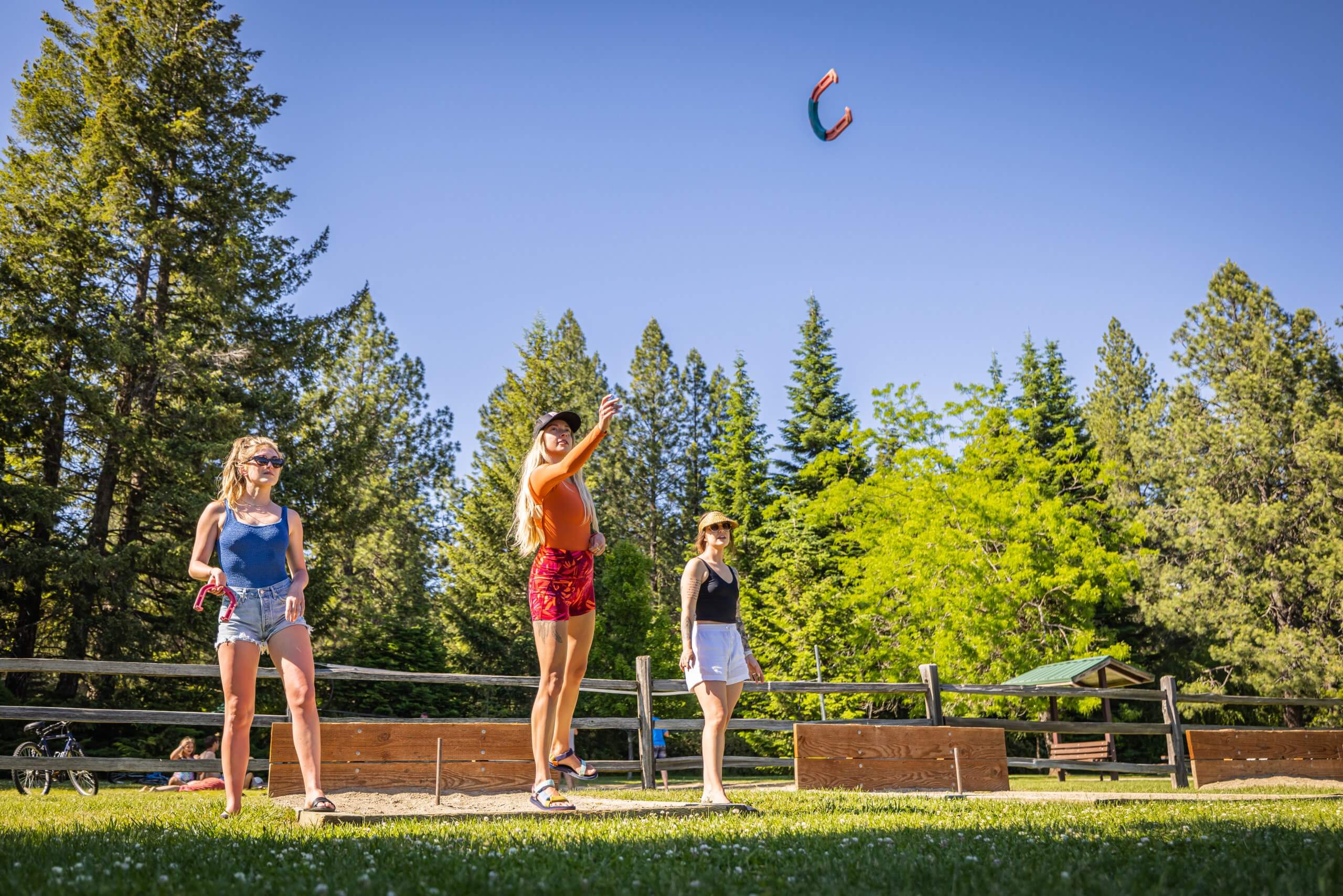 three women playing horseshoes.