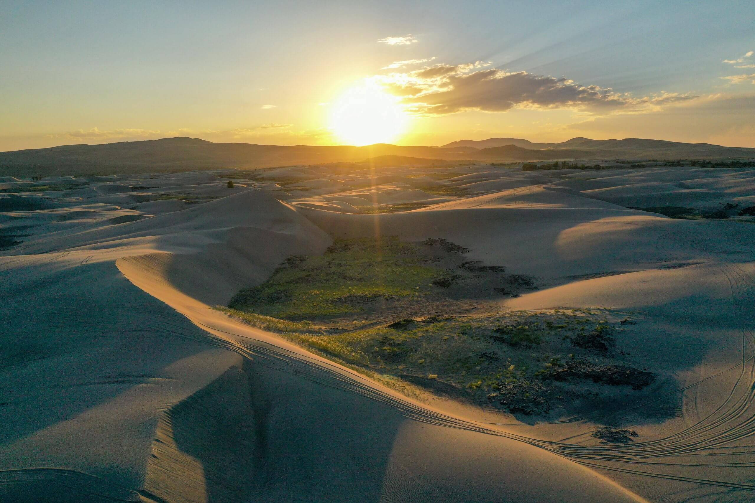 A dazzling sunset shines above the St. Anthony Sand Dunes.