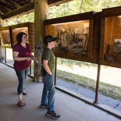 A mother and son look at exhibits at the Marble Creek Historical Park.