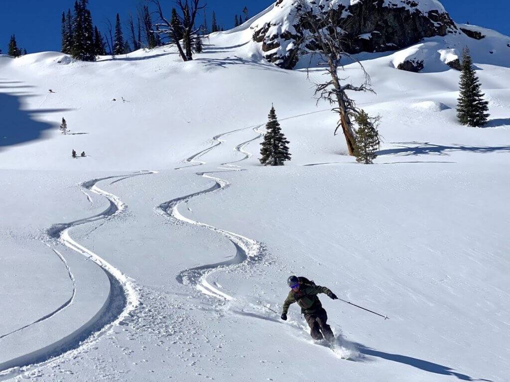 skier making fresh tracks on snow-covered mountain