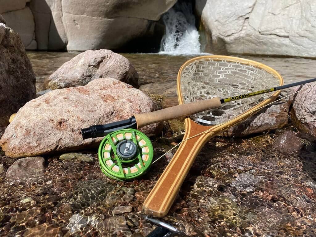 A 9-foot 5-weight fly fishing rod resting in a riverbed.