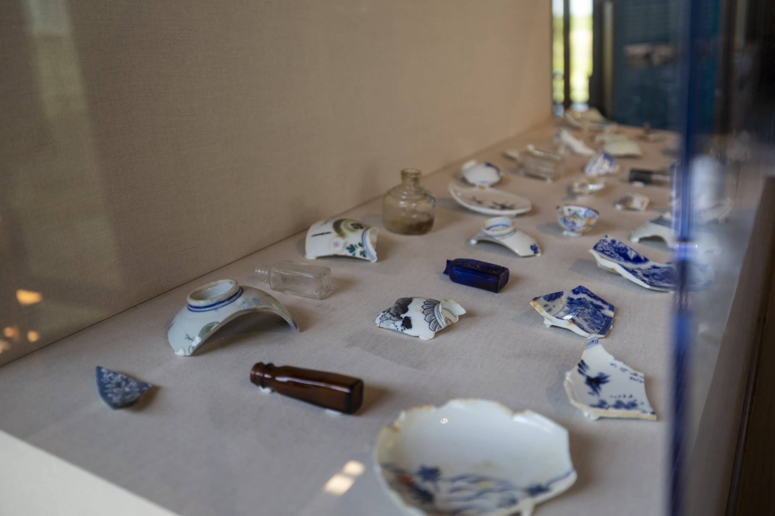 An exhibit containing glass bottles and broken china at the visitor center at Minidoka National Historic Site.