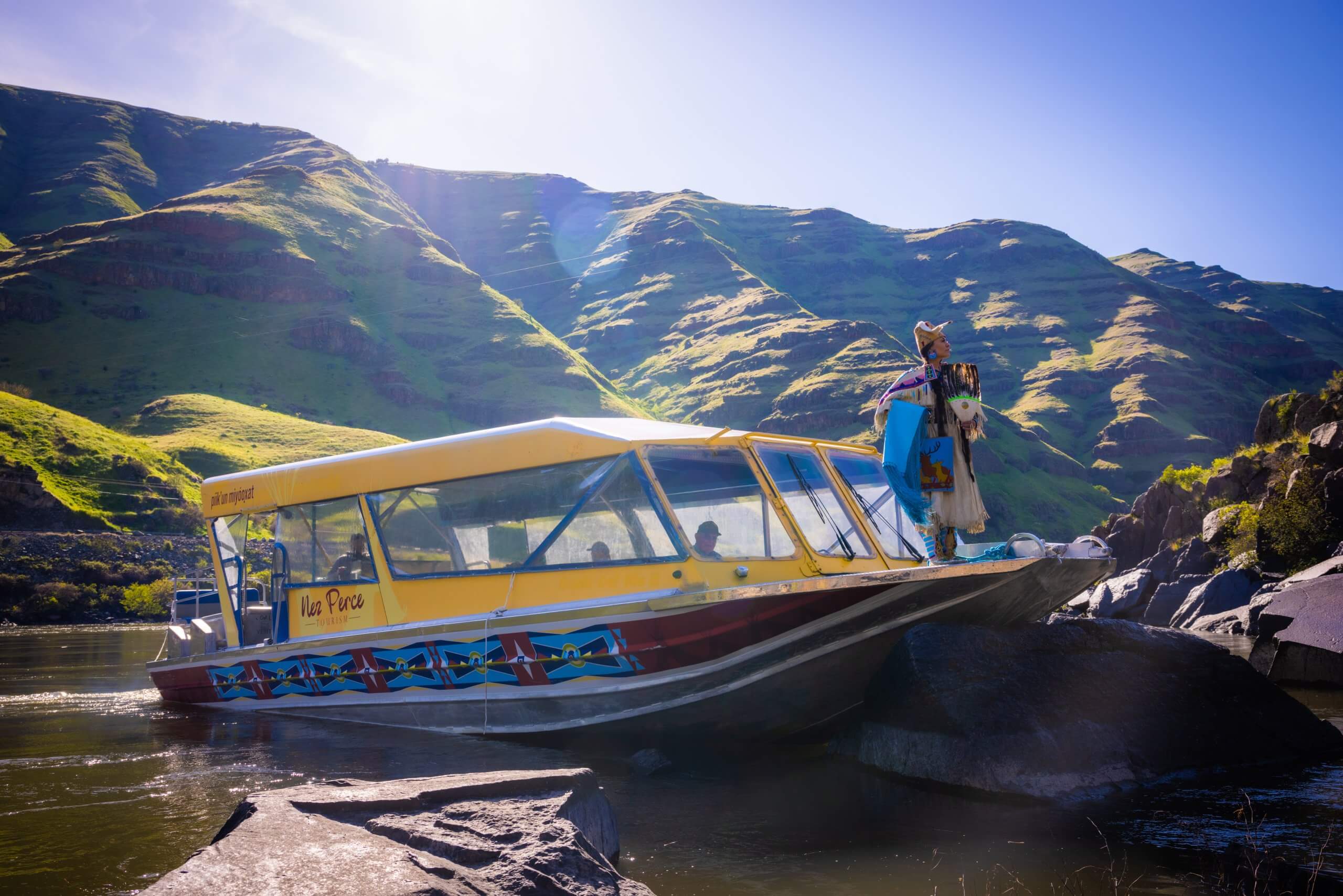 A Nez Perce woman stands at the edge of a jet boat.