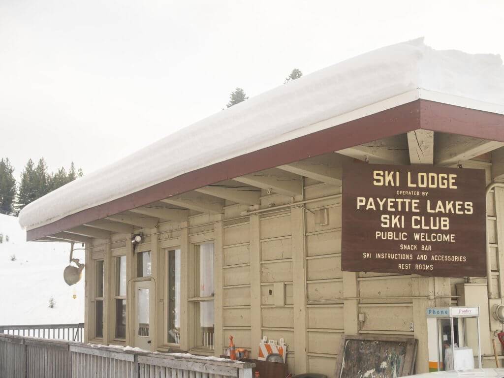 beige exterior of the ski lodge at little ski hill covered in a few inches of snow