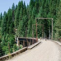 People ride bikes on an old railroad trestle.