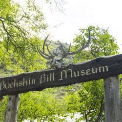 A wooden sign for Buckskin Bill Museum.