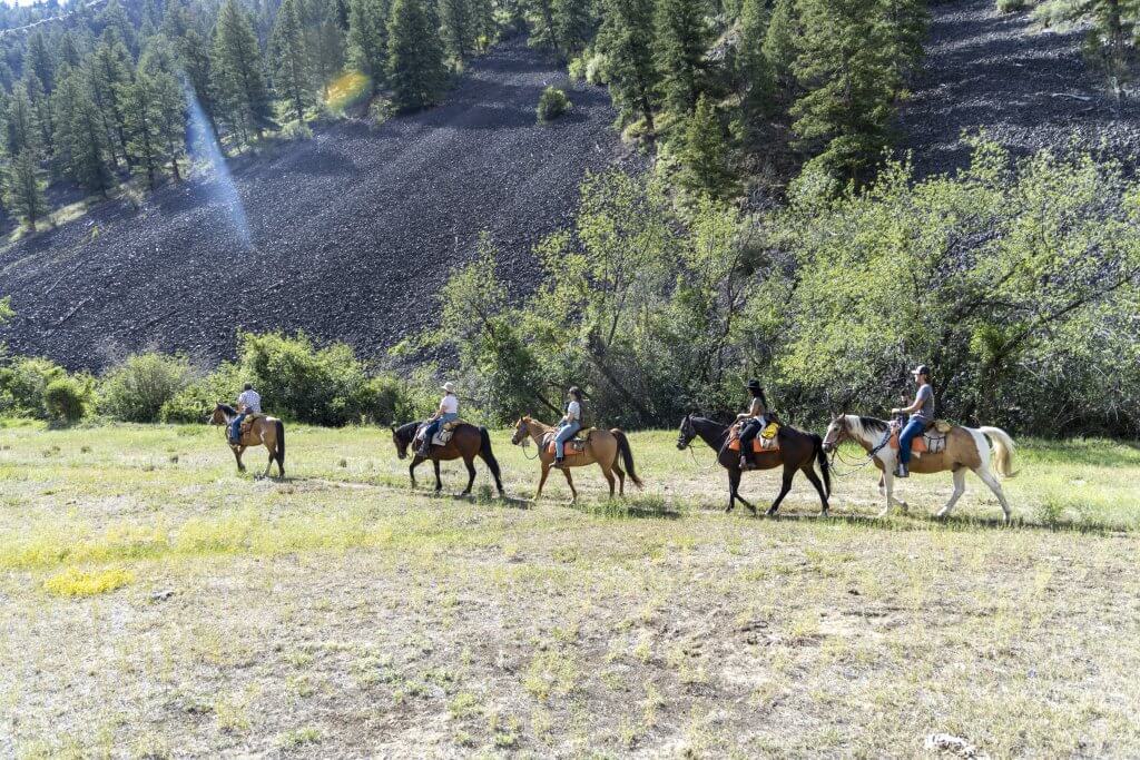 A group of people ride horses with Rawhide Outfitters near Salmon.