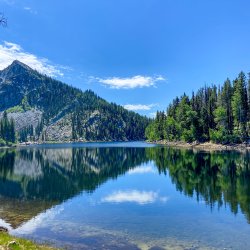 A view of Louie Lake with the Payette National Forest and mountains in the background.