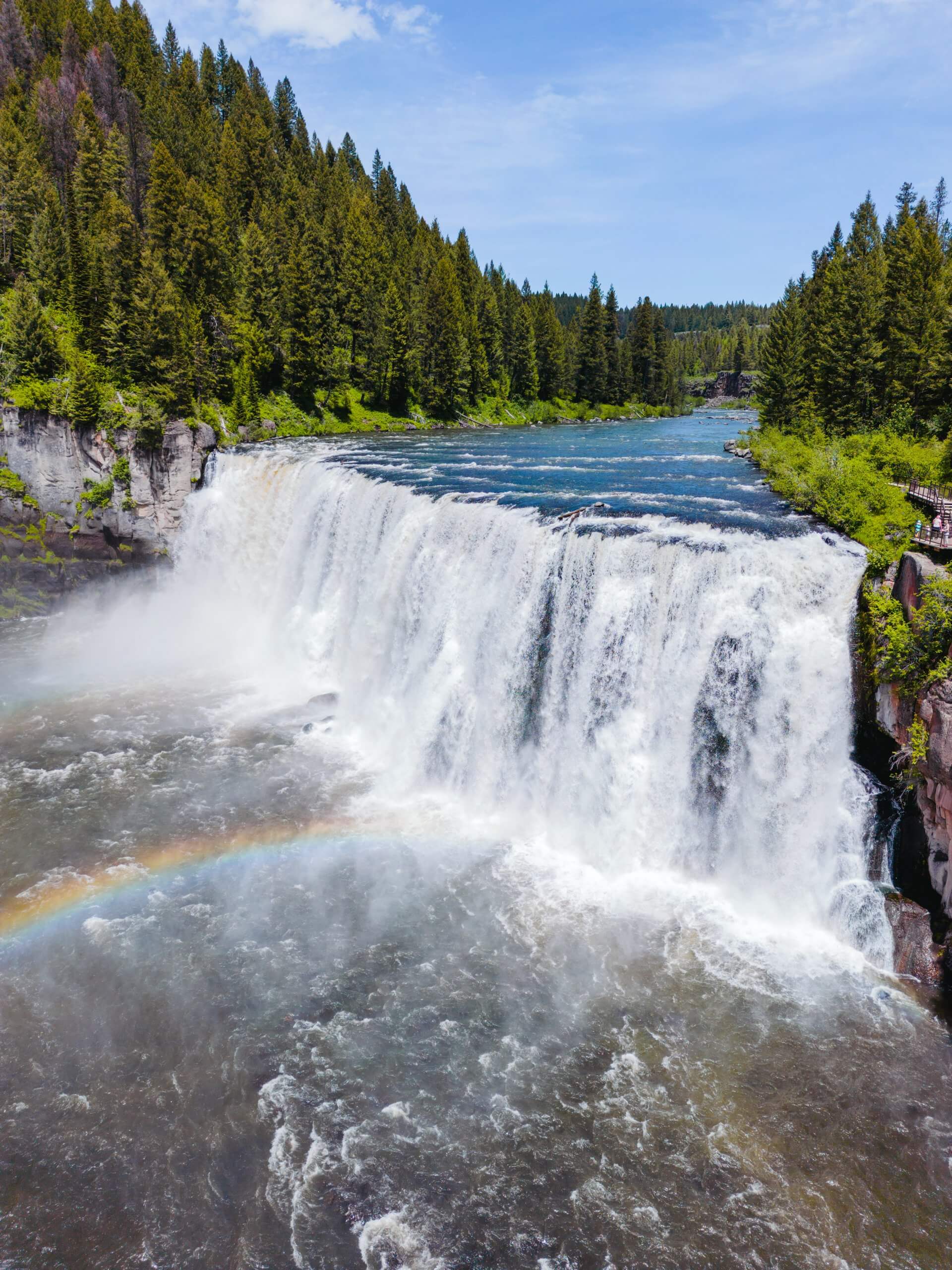 A wide angle aerial look at the massive Mesa Falls as it tumbles over a rocky ledge.