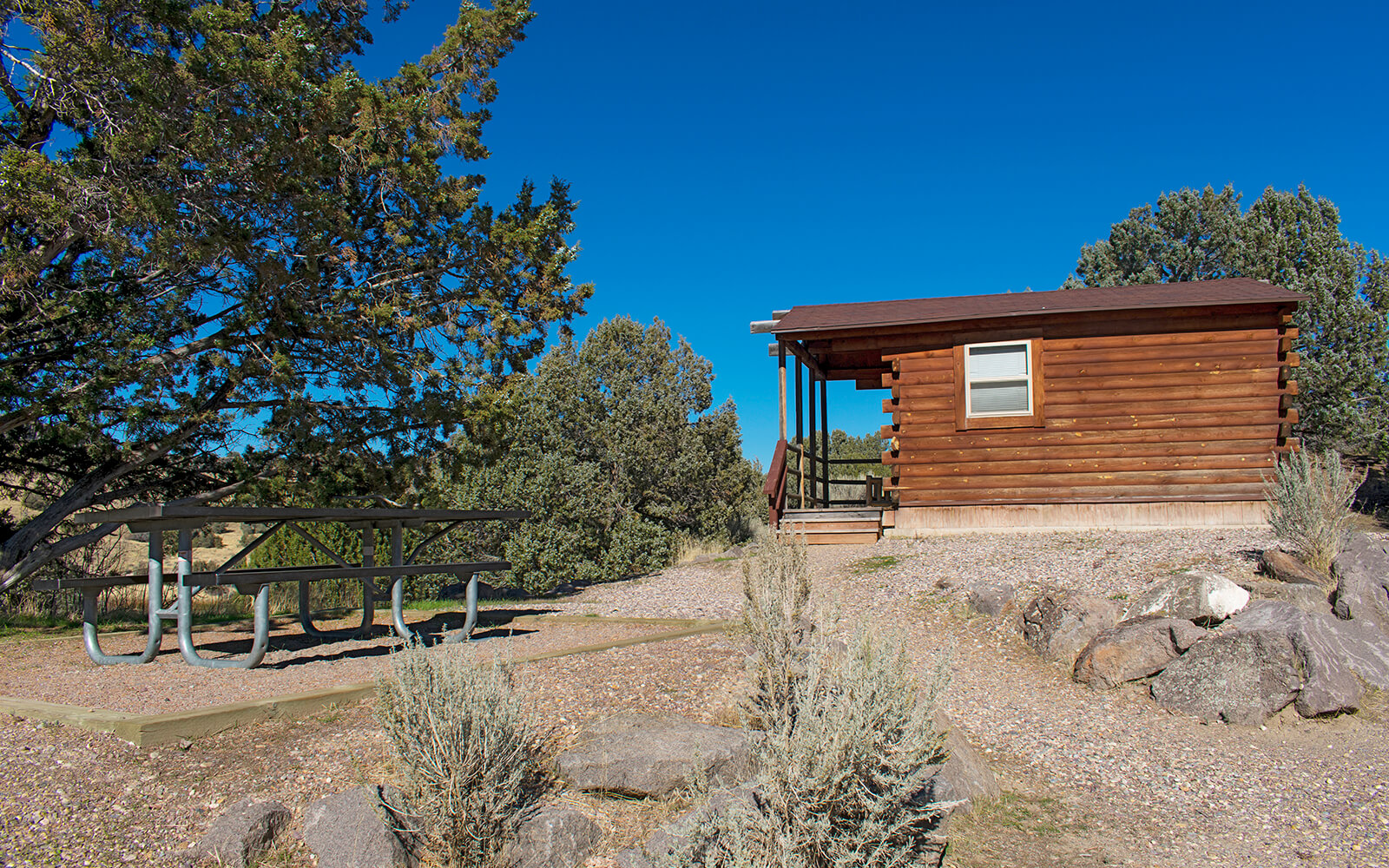 Log cabin and picnic table at Massacre Rocks State Park.