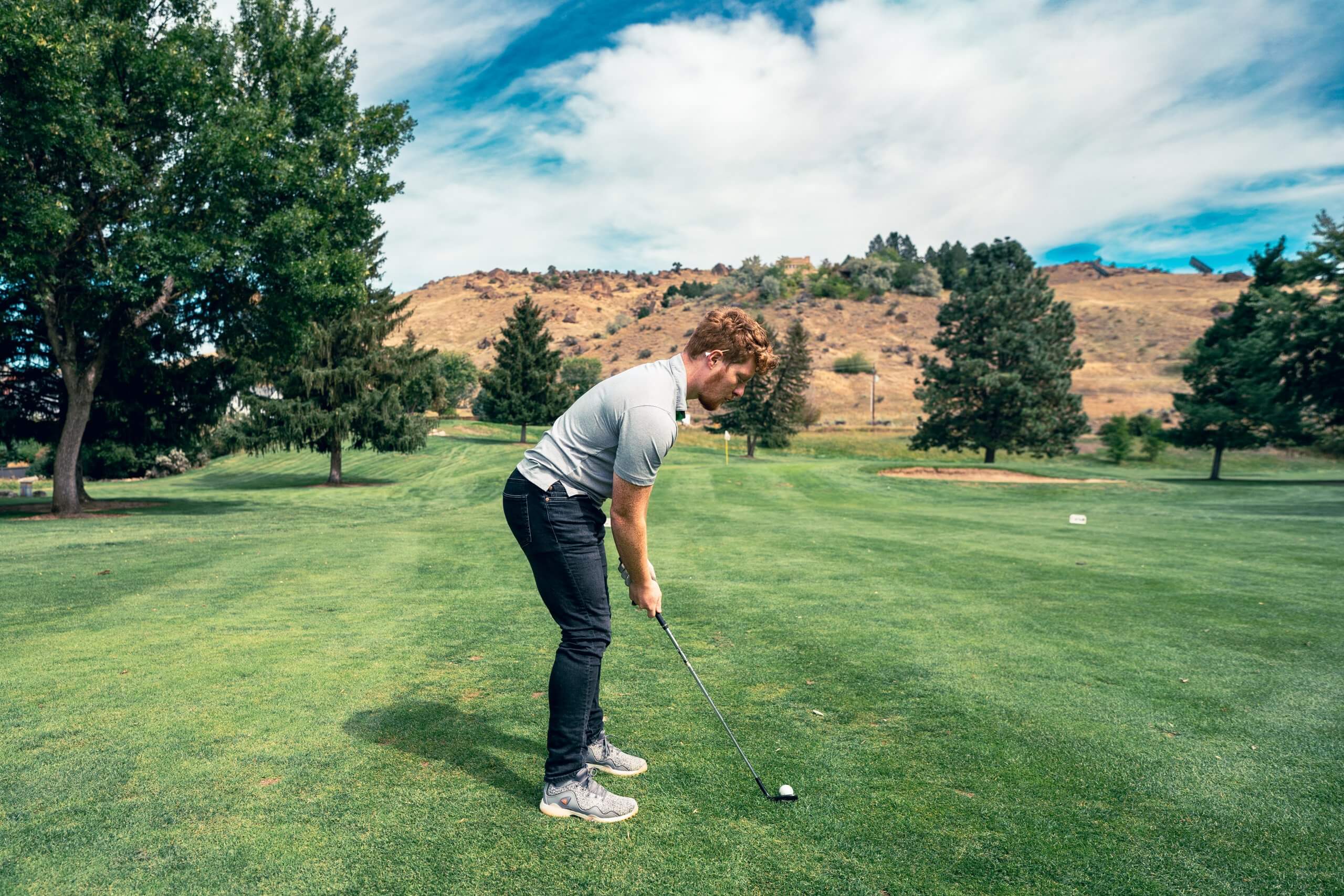 Man prepares to swing golf club at Warm Springs Golf Course.