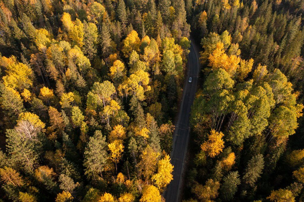 Car drives on Upper Pack River Road near Sandpoint Idaho.