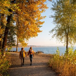 Two people walk along the Pend d'Oreille Bay Trail in Sandpoint Idaho.