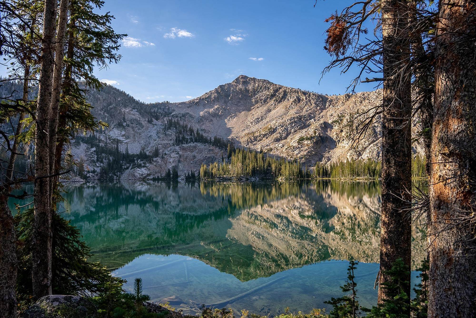 A scenic shot of the Sawtooth Mountains behind a clear lake.