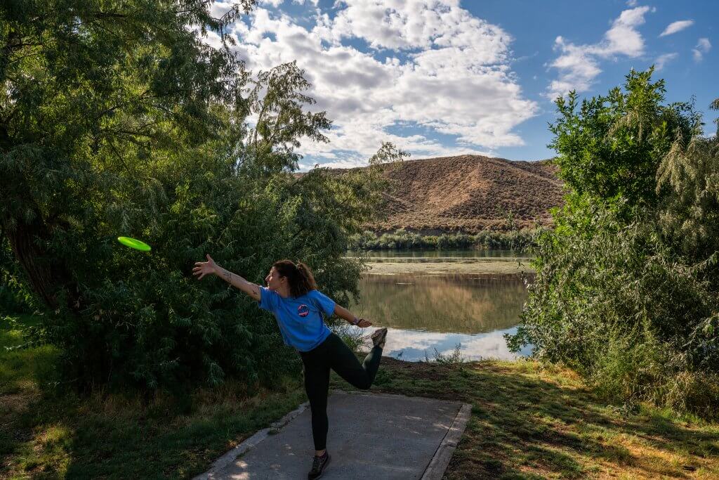 A woman playing disc golf at Three Island Crossing State Park.