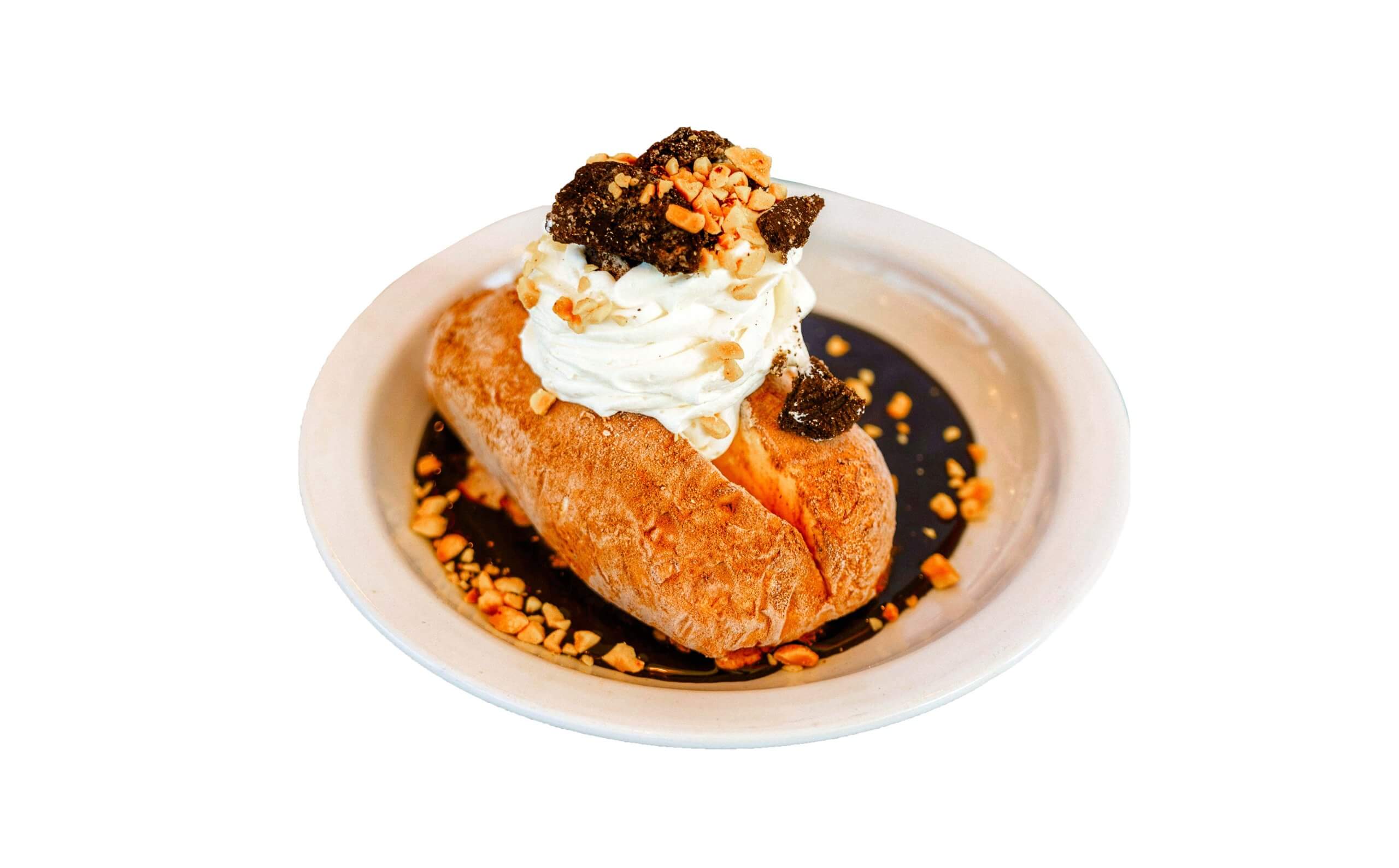 An ice cream potato from Westside Drive-In in a dish topped with whipped cream, cookie crumbles and nuts.