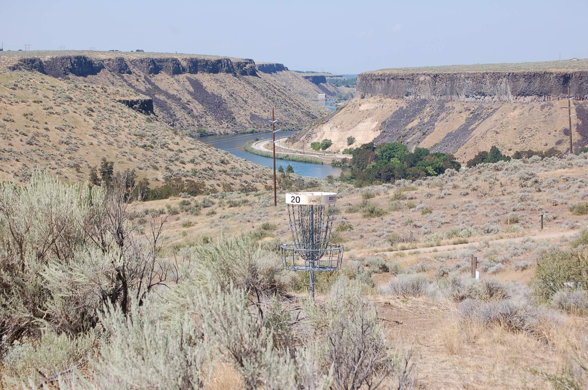 A disc golf basket with mountains in the background at Lucky Peak State Park.