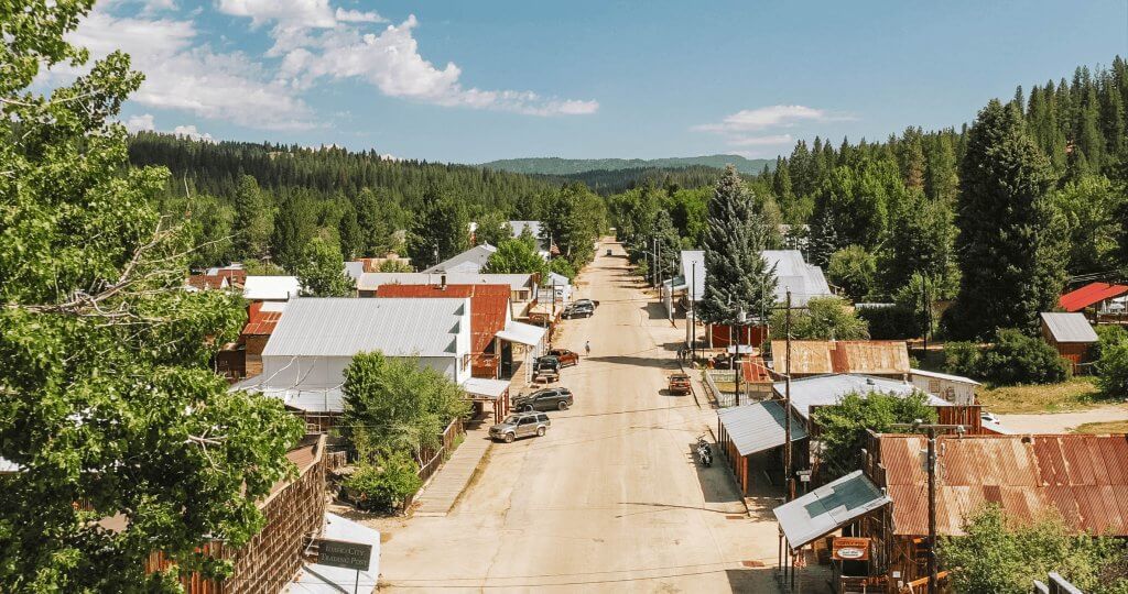 A view of Main Street with houses and cars as the Ponderosa Pine outline the street in a scenic landscape.