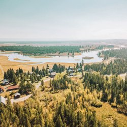 An aerial view of a state park made up of buildings, forest and river during fall.