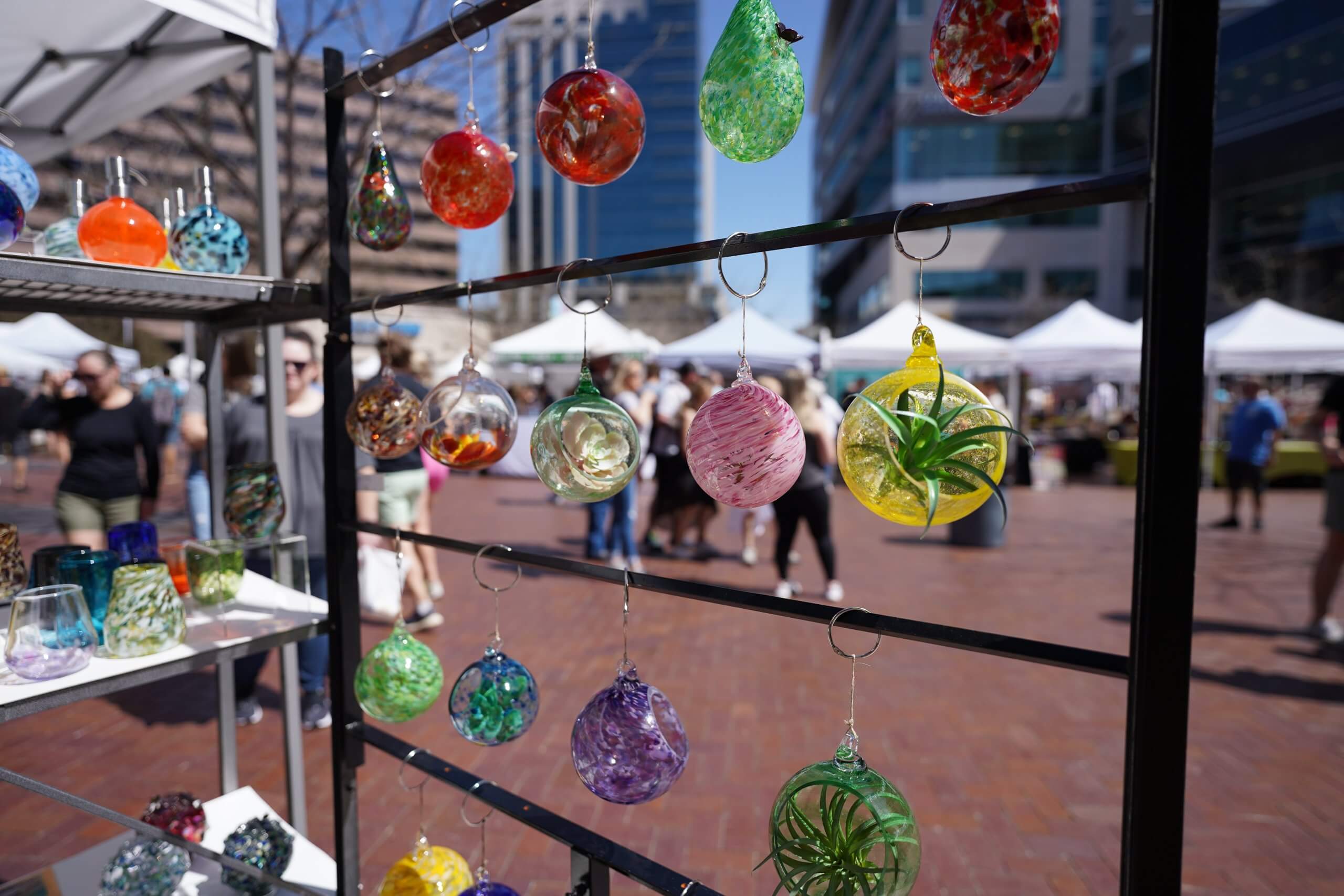 glass sculptures hang at Saturday market booth