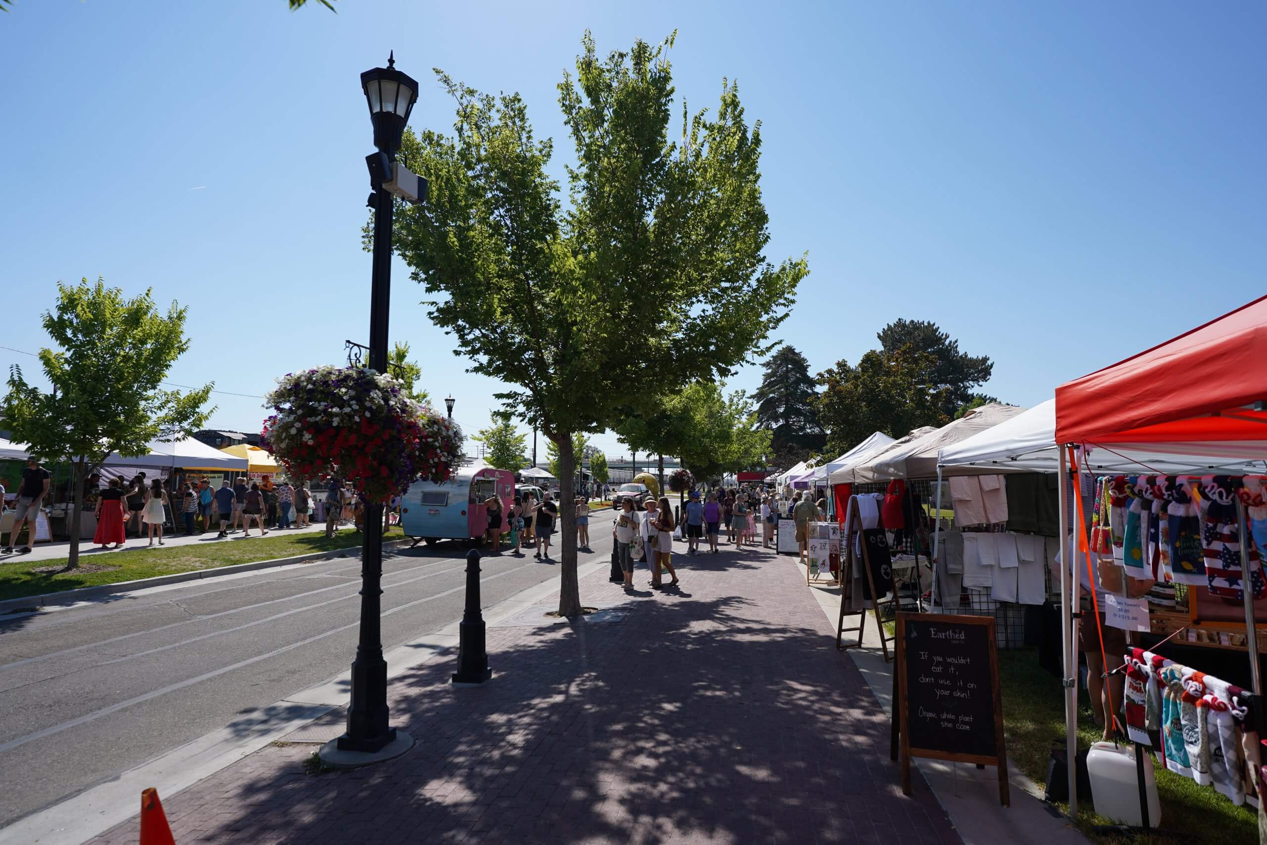 people walk around a farmers market