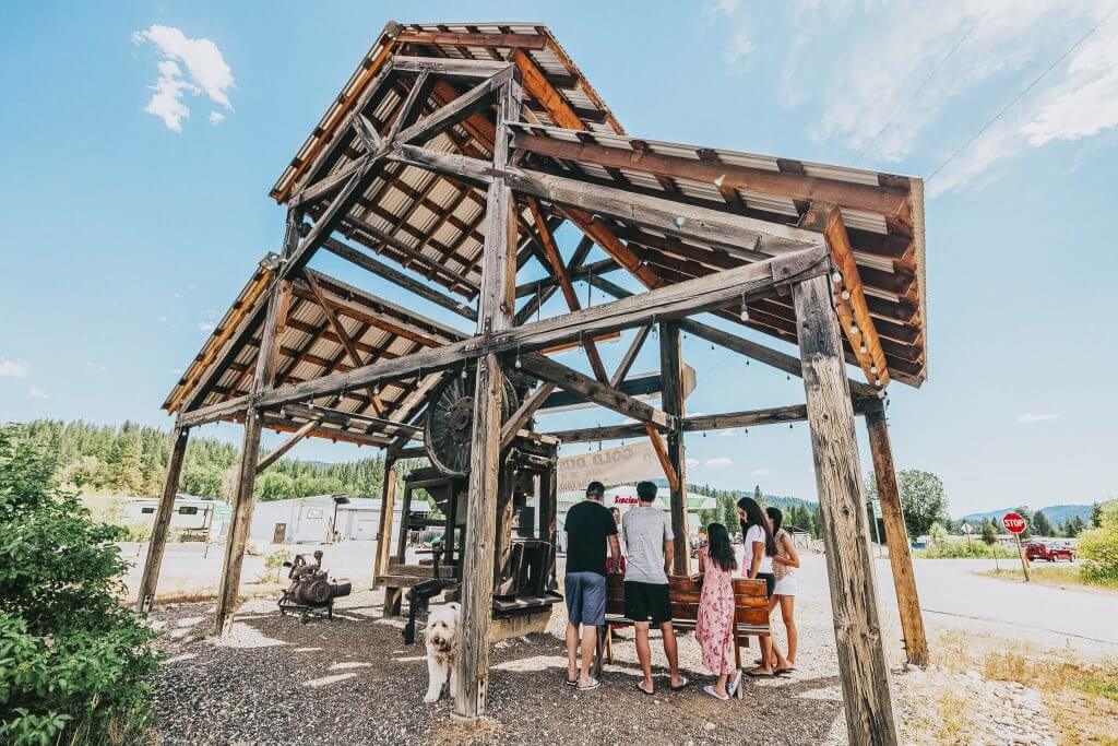 A group of people outside, at a mining equipment exhibit in Idaho City.