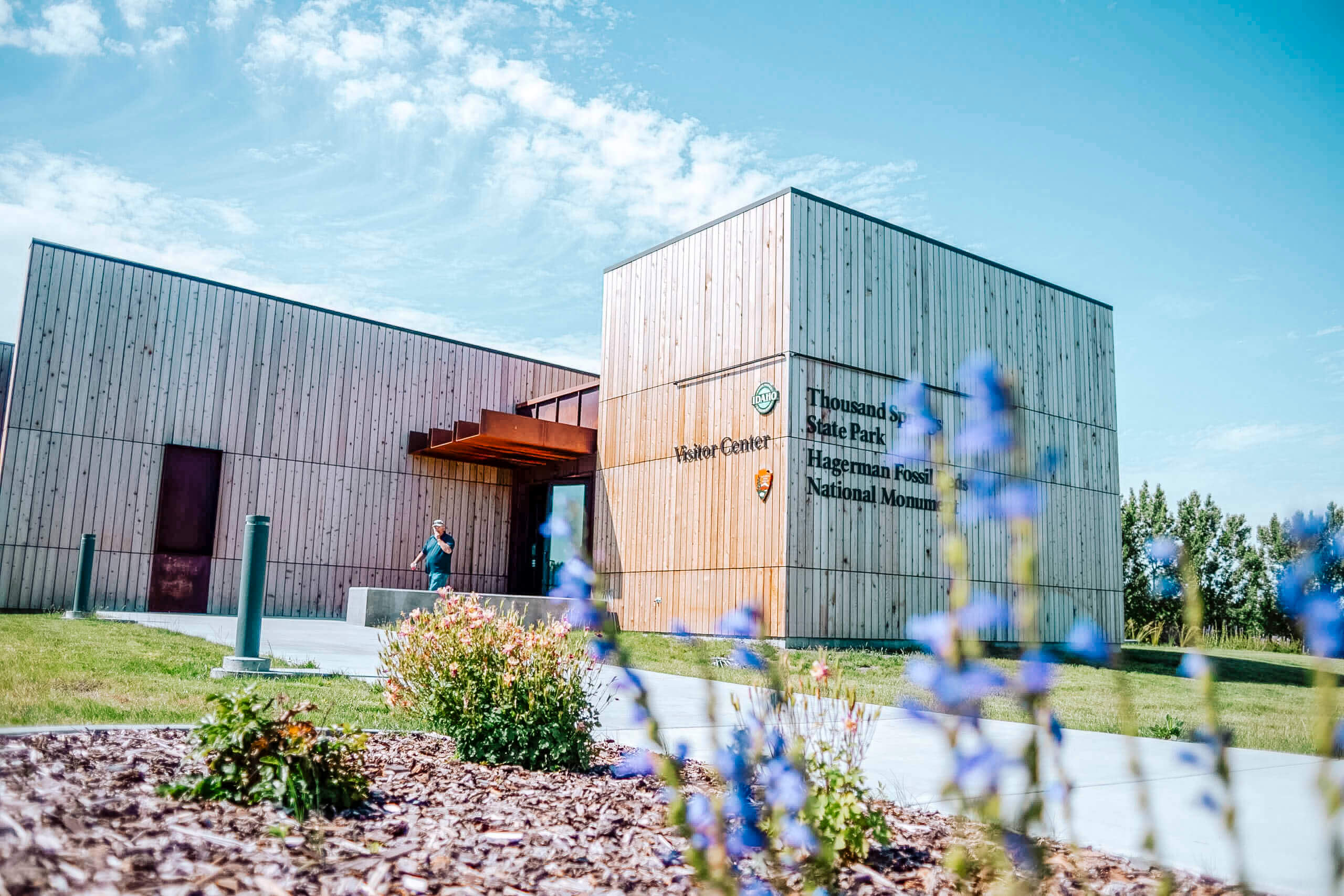 Front view of the Hagerman Fossil Beds National Monument at the Thousand Springs State Park Visitor Center with purple flowers in the foreground.