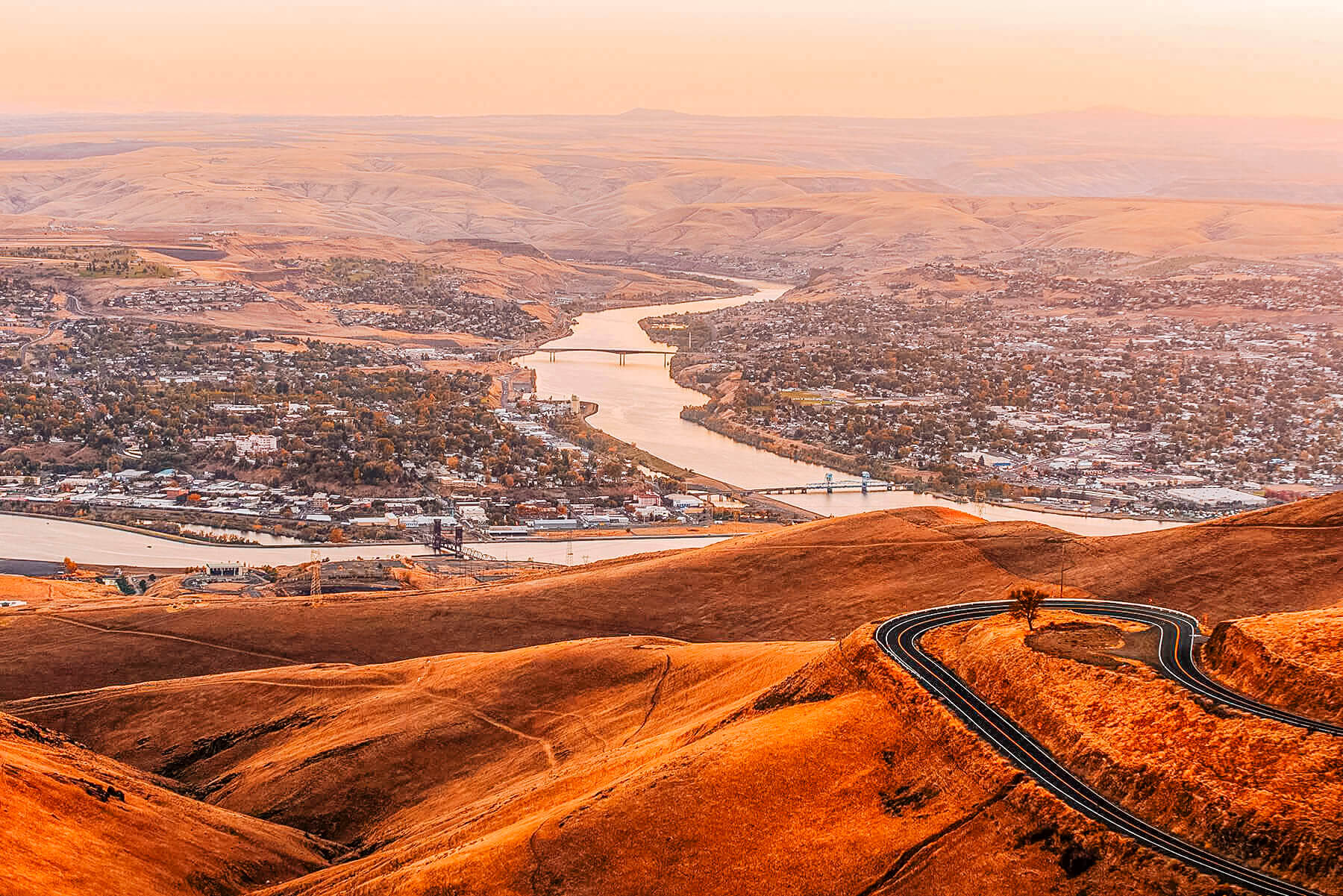 An aerial view of Lewiston valley and a road winding through the landscape in the foreground.