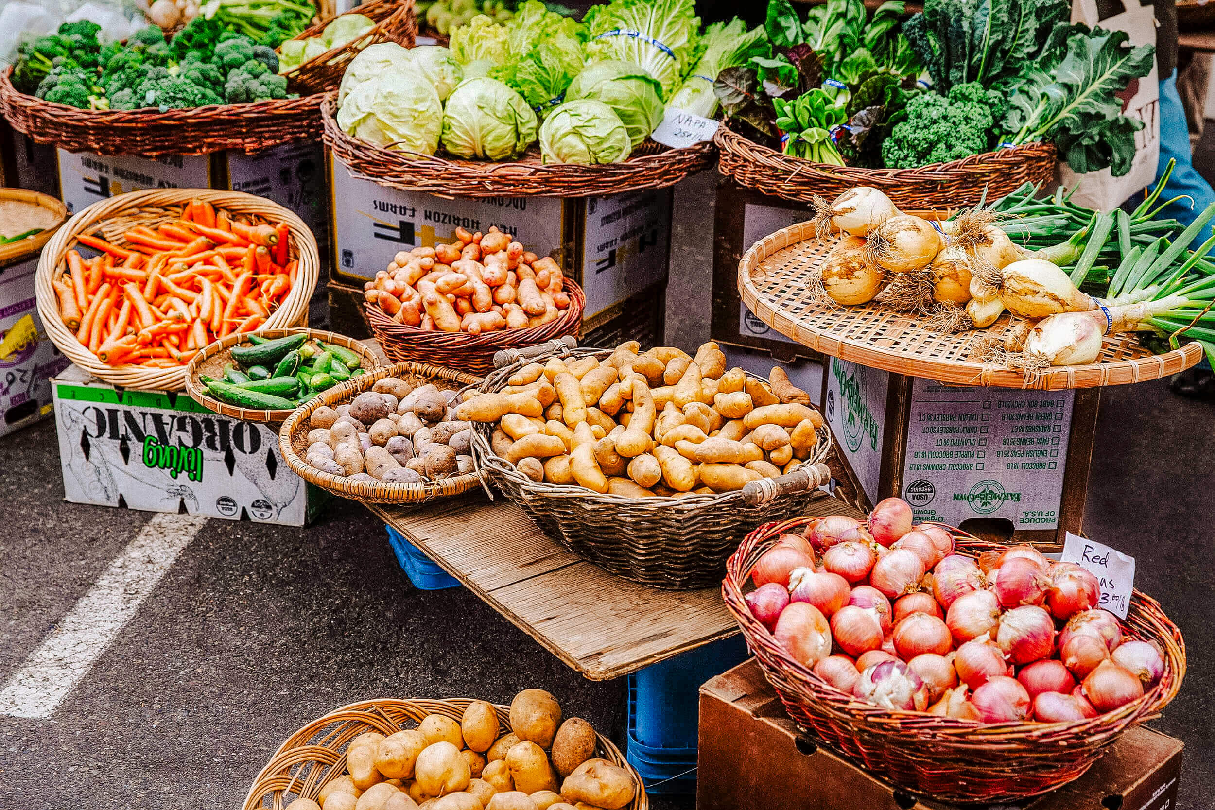 Fresh produce in baskets at a farmers market.