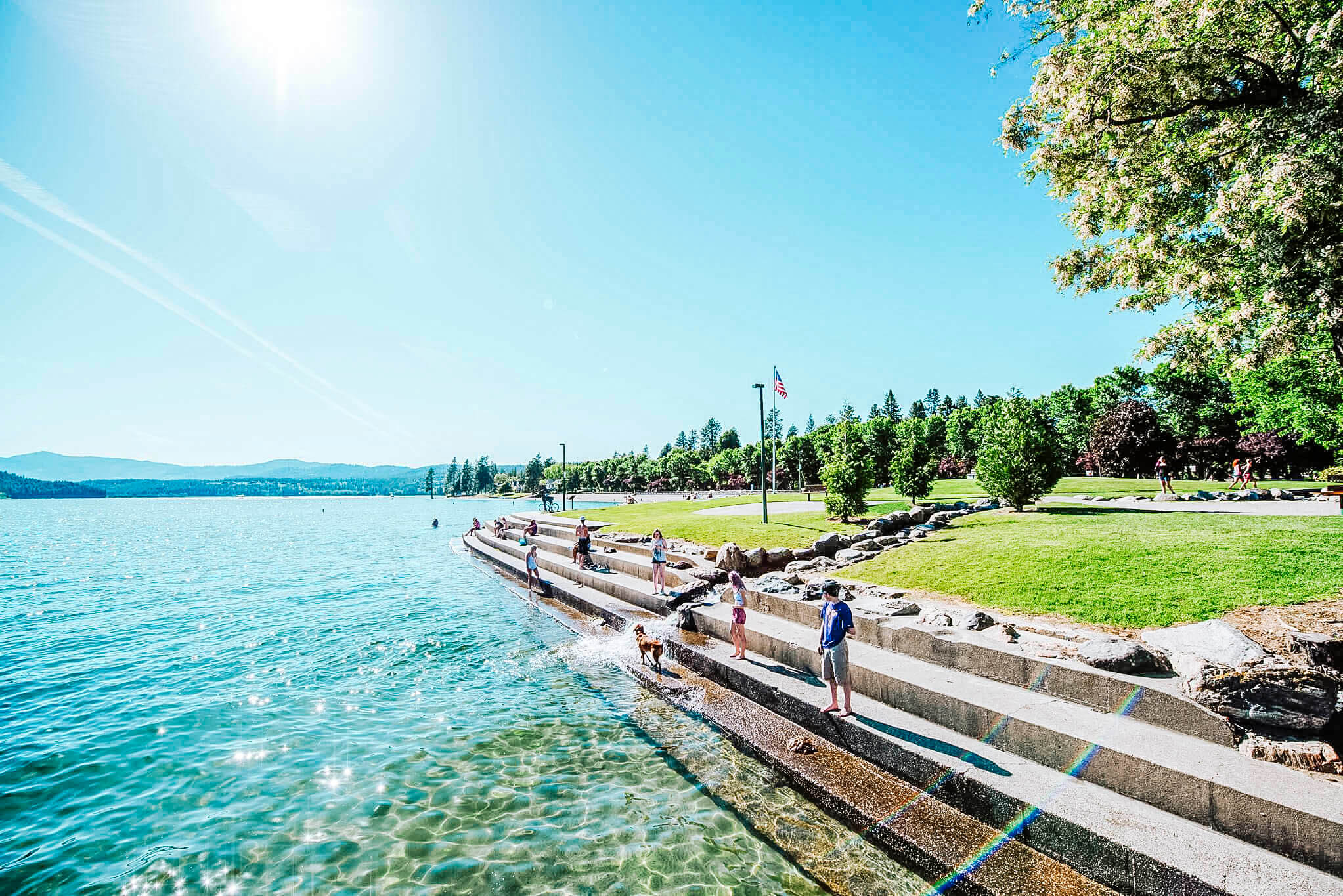 People stand alongside the water's edge at the City Park and Beach.