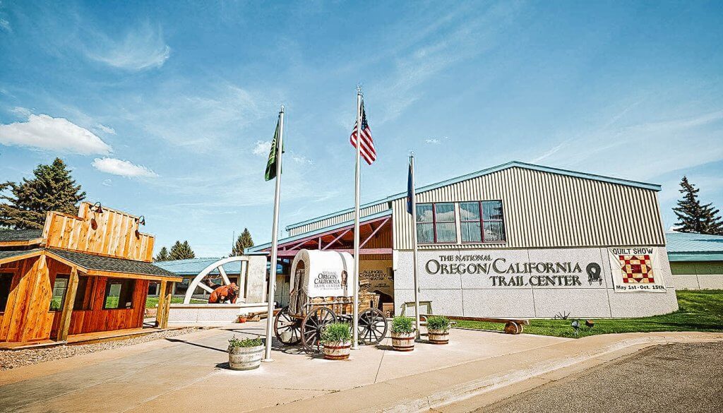 Front view of The National Oregon/California Trail Center building and a small covered wagon.