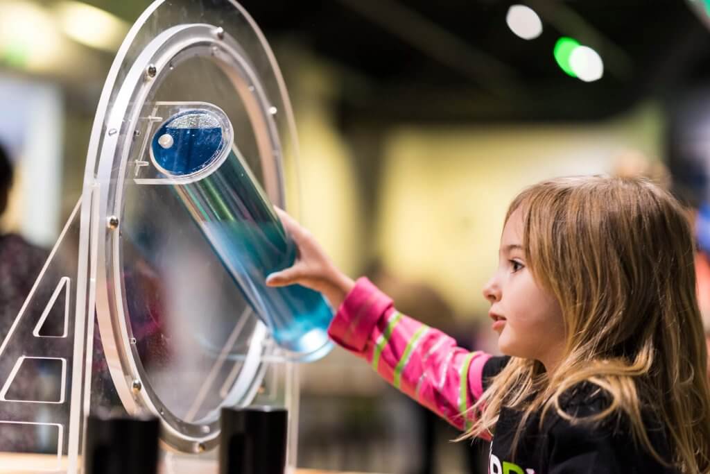 A girl at an interactive exhibit at the Discovery Center of Idaho.