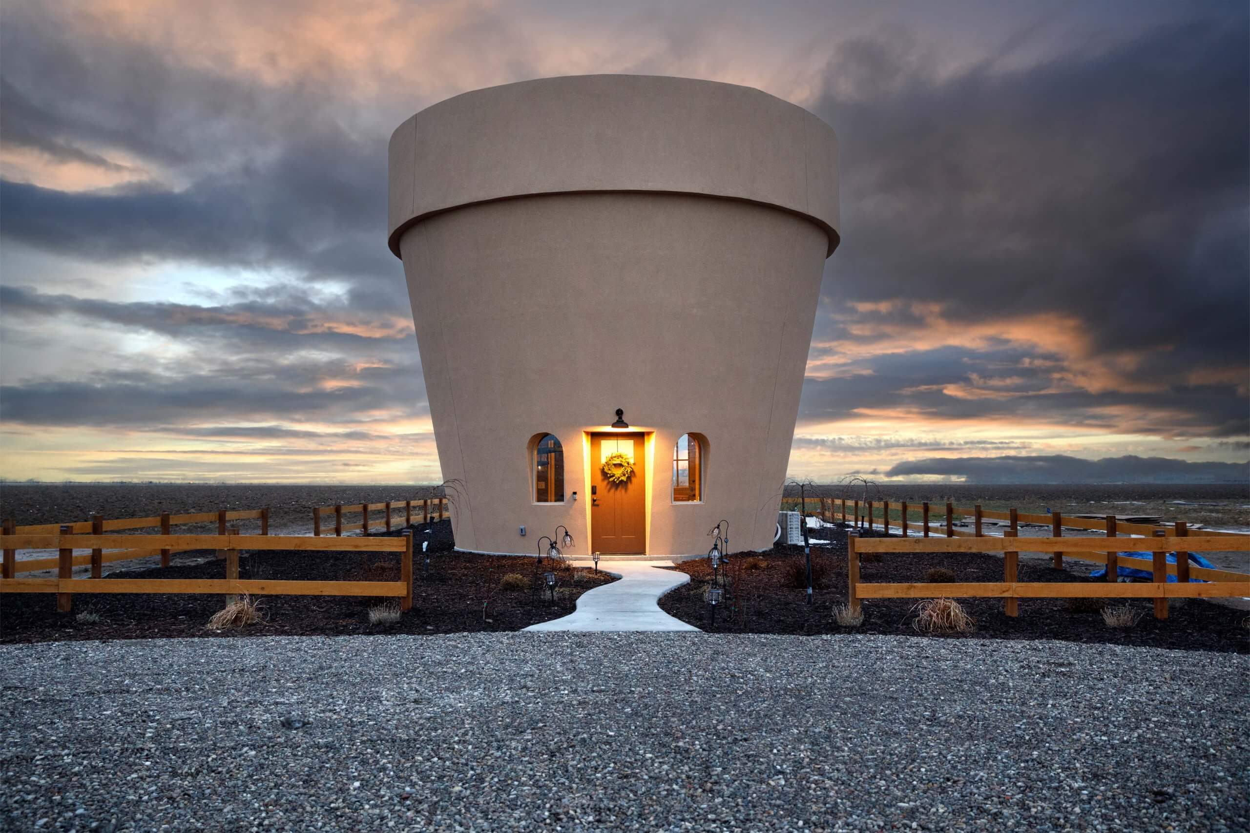 Sunset casts colors above the Flower Pot in Burley, Idaho, as the door glows in the life-sized flower pot home.