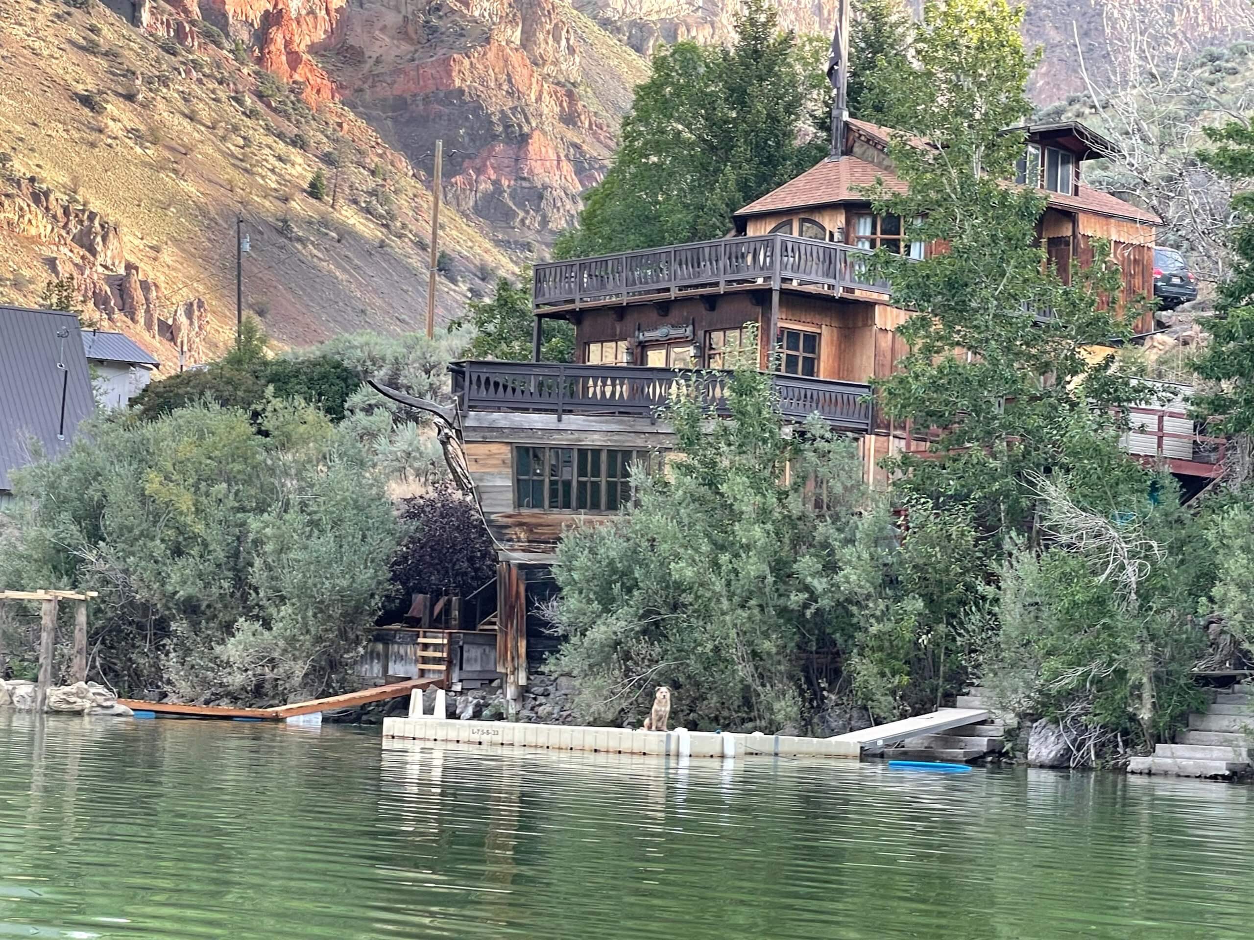 A beautiful lake view, where from a distance, the Shipwreck House stands overlooking the trees and waters of Williams Lake in Salmon, Idaho.