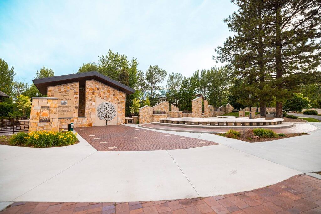 A view of the stone building and monuments at the Idaho Anne Frank Human Rights Memorial surrounded by trees