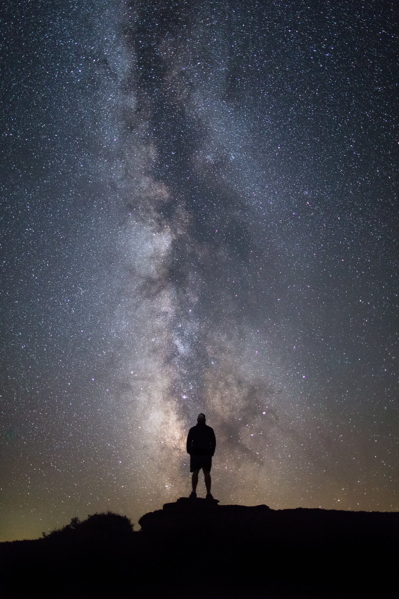 A silhouette of a person looking at the Milky Way at the Inferno Cone at the Craters of the Moon National Monument & Preserve.