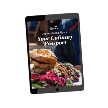 An iPad showing the words Dig Into Idaho Flavor: Your Culinary Passport on top of an image of a breakfast dish topped with a sunny side up egg.