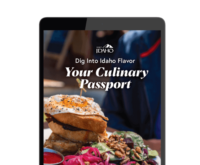 An iPad showing the words Dig Into Idaho Flavor: Your Culinary Passport on top of an image of a breakfast dish topped with a sunny side up egg.