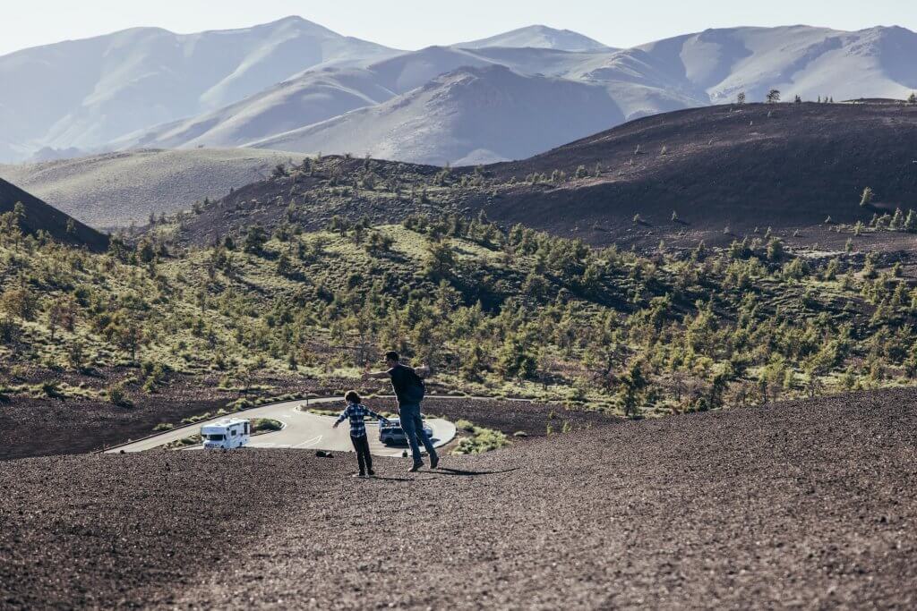 A father and son walking down a trail at Inferno Cone Lookout at Craters of the Moon National Monument & Preserve.